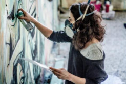 Foto di Alice Pasquini mentre dipinge